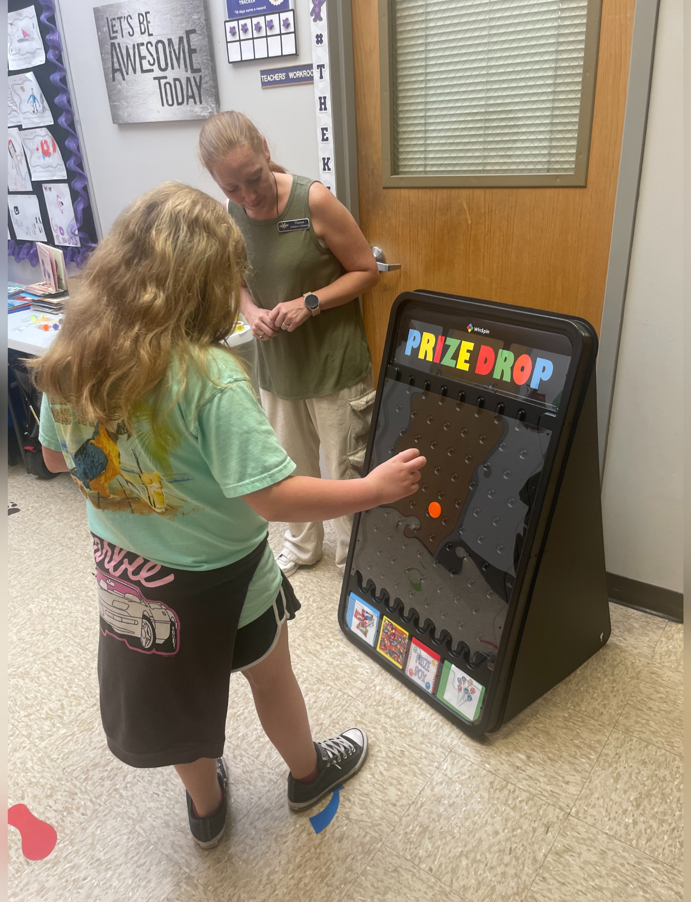 Beck watches as a student plays the prize drop game.