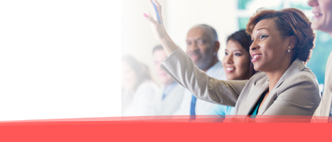 photo: smiling woman at a meeting raising her hand