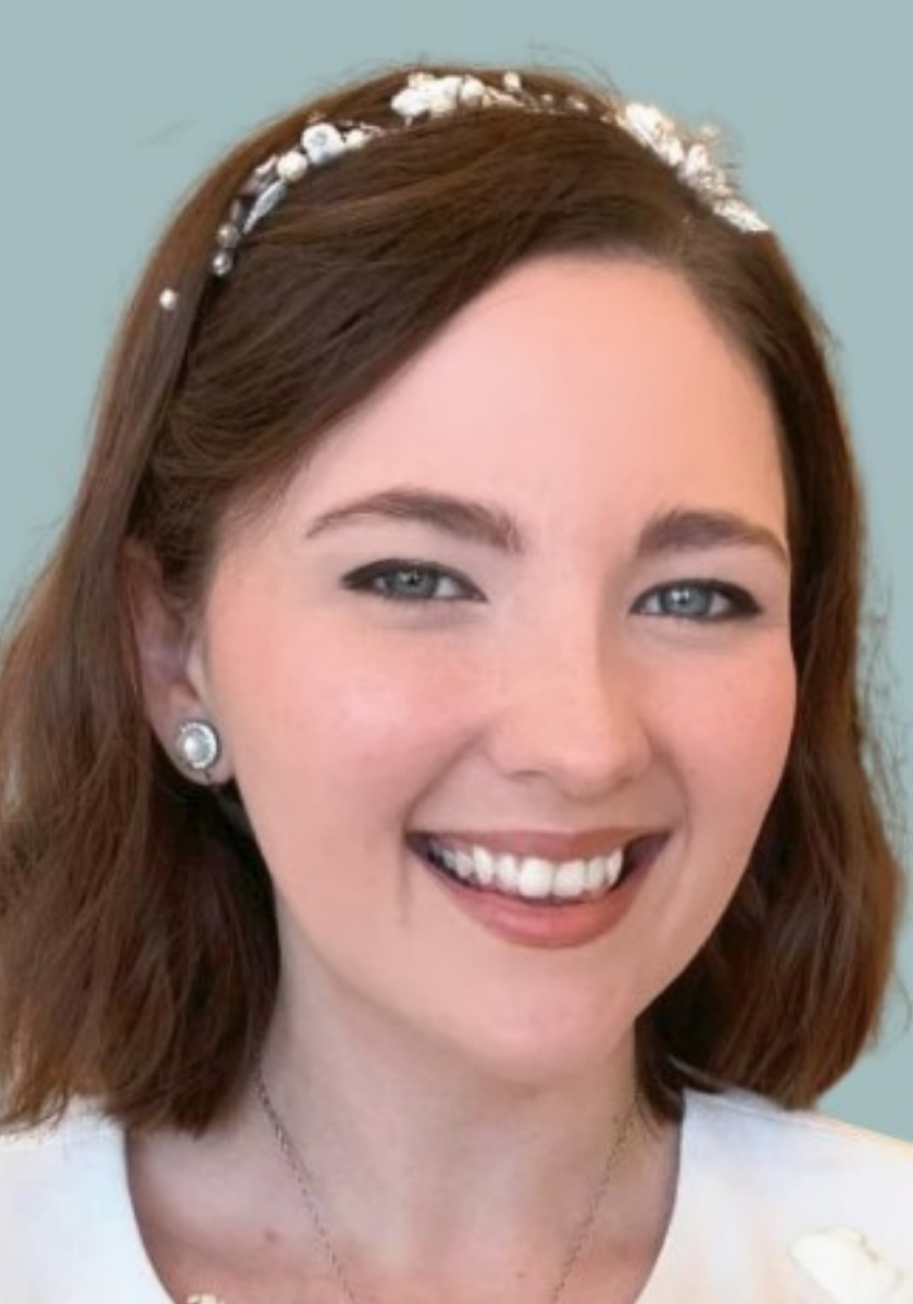 Andie Batt headshot. A young white woman with reddish brown hair.