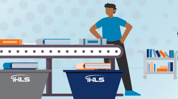 Alt text:  Image of two people using an AMHS conveyor belt to sort books into bins marked "IHLS." Nearby are bins full of books. Further in the background is a person pulling books from a shelf and filling a book cart.